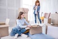 Cheerful young girls cleaning apartment and unpacking Royalty Free Stock Photo