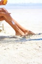 Working on her tan. a young woman applying suntan lotion while relaxing at the beach. Royalty Free Stock Photo