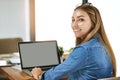 Working her way to a great GPA. Portrait of a smiling female university student working on a laptop on campus.