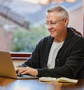 Working on his retirement plan. a handsome senior man working on his laptop in the study. Royalty Free Stock Photo