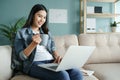 Working from home. beautiful of young woman using computer laptop while sitting on the sofa in the living room in the morning at Royalty Free Stock Photo