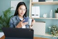 Working from home. beautiful of young woman using mobile phone  while sitting on the table at house in the morning Royalty Free Stock Photo