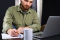 Working from home, casual business man using laptop computer, writing on notebook with cup of tea on table. Student Royalty Free Stock Photo