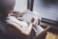 Working at home concept. Young business woman writing and taking notes while relax sitting in comfort chair at home Royalty Free Stock Photo