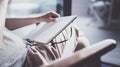 Working at home concept. Young business woman writing and taking notes while relax sitting in comfort chair at home Royalty Free Stock Photo