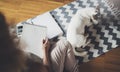 Working at home concept. Young business woman writing and taking notes while relax sitting in comfort chair at home Royalty Free Stock Photo