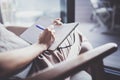 Working at home concept. Young business woman writing and taking notes while relax sitting in comfort chair at home Royalty Free Stock Photo