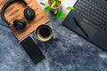 Working from home. Desk office with laptop, notepad, coffee cup, headphones and plant