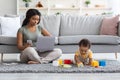 Working From Home. Freelancer Lady Using Laptop And Smartphone While Babysitting Child Royalty Free Stock Photo