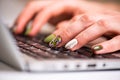 Working at home with laptop woman writing a beauty blog. Female hands with bright manicure on the laptop keyboard Royalty Free Stock Photo