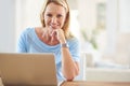 Working from home makes me happy. Cropped portrait of an attractive mature woman sitting and using a laptop while in her Royalty Free Stock Photo