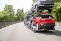 Working horse big rig car hauler semi truck transporting cars on the two level hydraulic semi trailer driving on the multiline Royalty Free Stock Photo