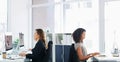 Working individually to achieve a common goal. a group of young businesswomen using their computers in a modern office. Royalty Free Stock Photo