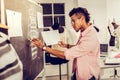 Fashion designer redrawing his sketch on a blackboard.