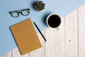 Working items with notebook, pencil, coffee cup and cactus over the blue and wooden background. Royalty Free Stock Photo