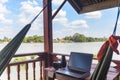 Working with laptop on wooden balcony in tourist resort with hanging hammock on the Mekong River, Laos. Concept of millenials Royalty Free Stock Photo