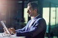 Working late means uninterrupted time to focus on the deadline. a businessman using a digital tablet while woking late Royalty Free Stock Photo