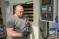 A working machine operator inspects and changes a cutting tool in the tool shop of a CNC milling machine Royalty Free Stock Photo