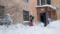 Working man is busy cleaning snow