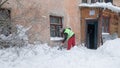 Working man is busy cleaning snow