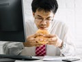Working men do not have time urgent eating junk food hamburger while working in office Royalty Free Stock Photo