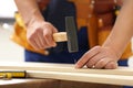 Working man hammering nail into timber , closeup. Home repair