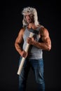 Working man hold hammer tool in muscular arms biceps triceps in casual wear black background, brutal
