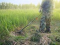 Working man mow high grass with electric lawn mower Royalty Free Stock Photo