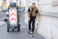 Working man standing near dustbin on street Royalty Free Stock Photo