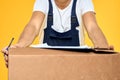 Working man in uniform with box hand delivery loading service yellow background