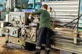 A working man works on a lathe. Processing of metal blanks in a workshop in a modern factory. Industrial processing of metal