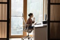 Indian female sit at workplace on ergonomic chair use pc