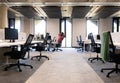 Working in modern office, man stretching at desk with computer monitors, copy space