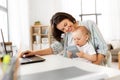 Working mother with baby boy and laptop at home Royalty Free Stock Photo