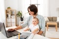 Working mother with baby boy and laptop at home Royalty Free Stock Photo