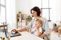 Working mother with baby boy and laptop at home Royalty Free Stock Photo