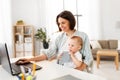 Working mother with baby boy and laptop at home Royalty Free Stock Photo