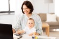 Working mother with baby boy and laptop at home Royalty Free Stock Photo