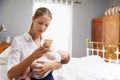 Working Mother Holding Baby And Checking Mobile Phone