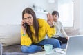 A working mother multitasking. Single mother with a kid trying to work. Worried woman working at home while her son is not letting