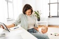 Working mother with tablet pc and baby at home Royalty Free Stock Photo