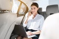 Female lawyer working on laptop, sitting in car