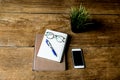 Working object notebook and pen with glasses and cell phone on wooden table. Royalty Free Stock Photo