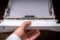 Working with an office printer: Male hand closes the printer`s paper tray. Loading paper in the tray Royalty Free Stock Photo