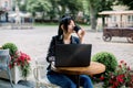 Working online, freelance concept. Young pretty smart Asian woman enjoying the coffee-break, using laptop computer Royalty Free Stock Photo