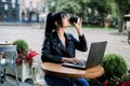 Working online, freelance concept. Young pretty smart Asian woman enjoying the coffee-break, using laptop computer Royalty Free Stock Photo