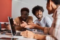 Smiling diverse coworkers sitting at desk in the separate room and making notes