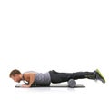 Working out energizes him. A young man doing push-ups on his exercise mat with his legs raised by a foam roller.