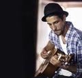 Working out a new song. A handsome young musician playing a guitar. Royalty Free Stock Photo