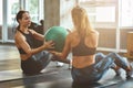 Working out together. Two young athletic women in sportswear exercising with ball at gym Royalty Free Stock Photo